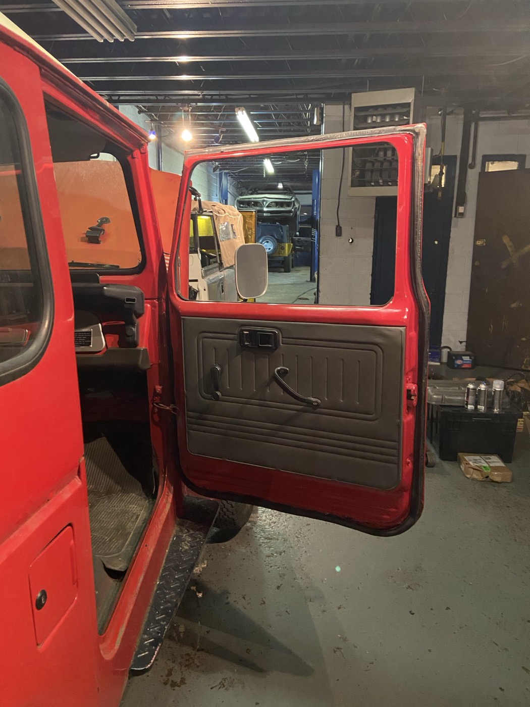 Open passenger door of the BJ40 showing the bare metal door card