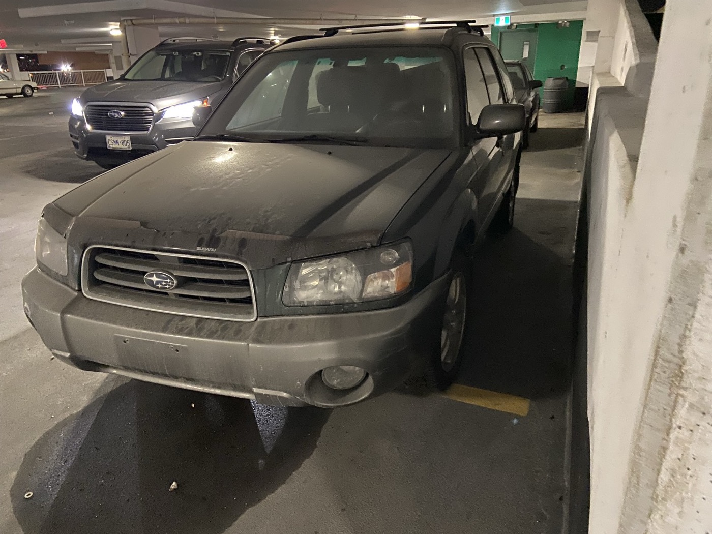 Green 2004 Subaru Forester XS, front view, in a parking garage