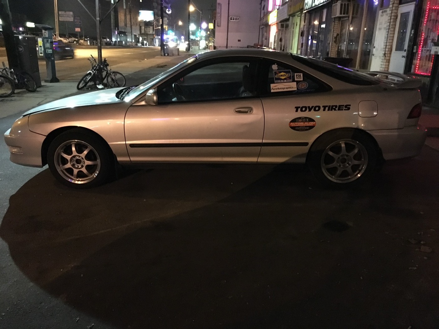 Silver 2000 Acura Integra LS with Toyo Tires decals, side view at night