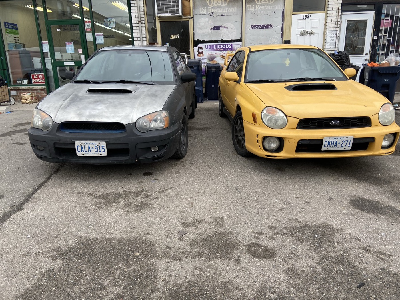 Sonic Yellow WRX next to a grey bugeye WRX outside a shop