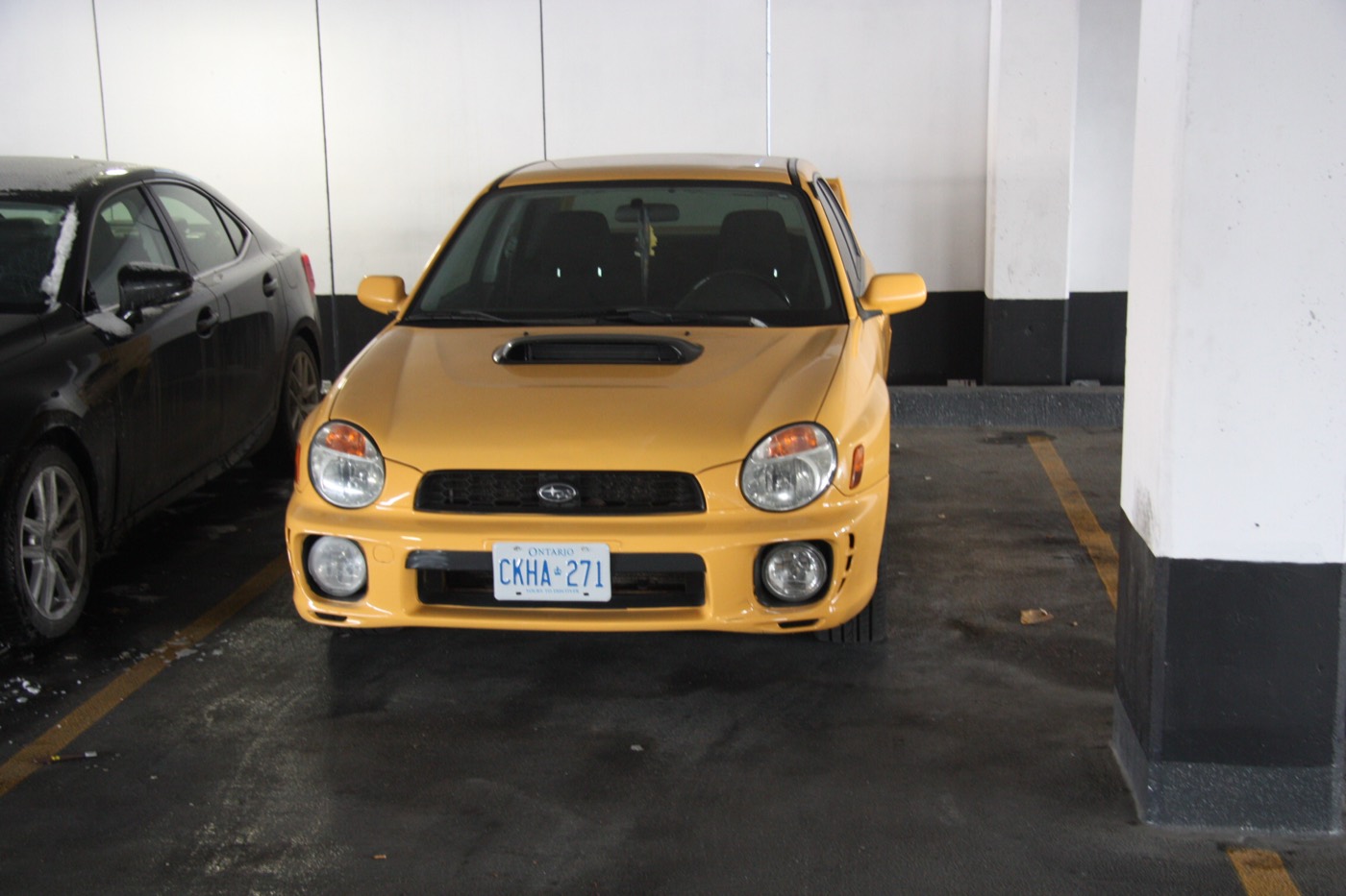 Yellow Subaru WRX in an underground parking garage