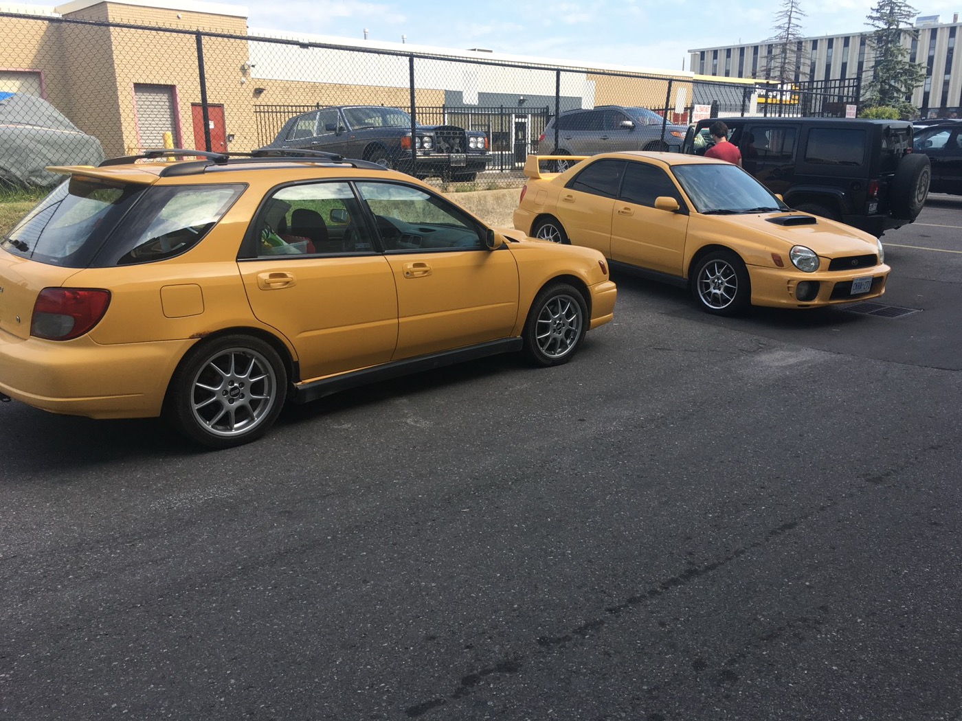 Sonic Yellow WRX wagon and sedan parked together in a lot