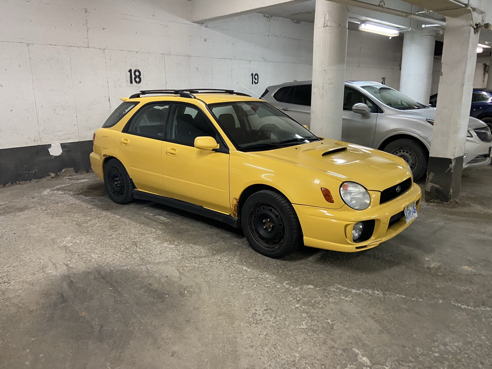 Yellow WRX wagon parked in an underground garage